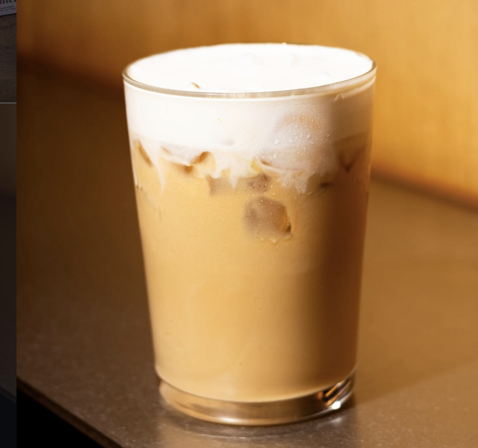 Intelligentsia Coffee — an iced latte in a clear glass with cold brew concentrate and milk against a warm golden background